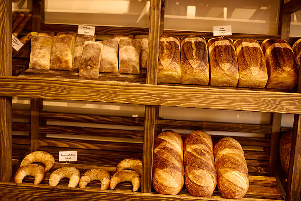 Freshly baked bread and croissants displayed on wooden shelves in a bakery