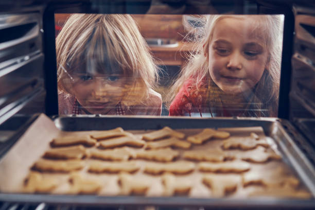 Little girls waiting for cookies to bake